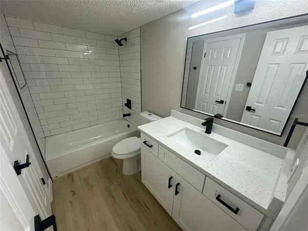 a bathroom with a sink a toilet a mirror and shower