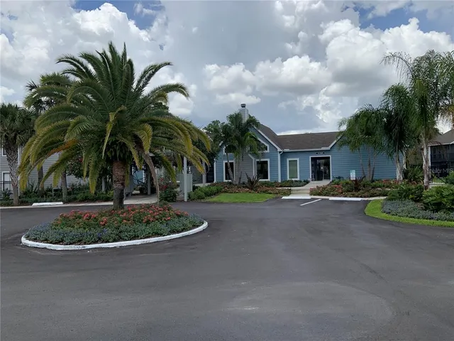 a front view of a house with garden and trees