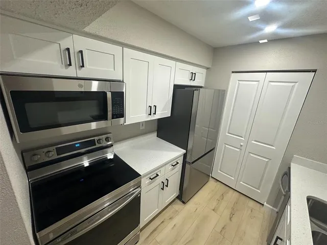 a kitchen with stainless steel appliances a refrigerator microwave and sink