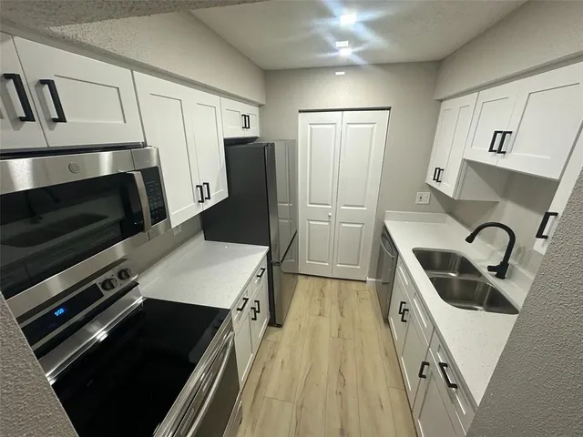a kitchen with a refrigerator stove and sink