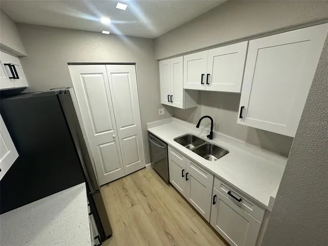 a kitchen with sink a refrigerator and cabinets