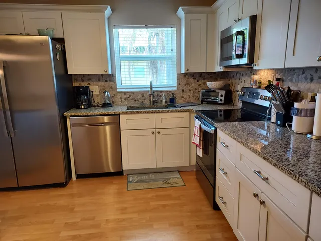 a kitchen with stainless steel appliances granite countertop a sink refrigerator and microwave