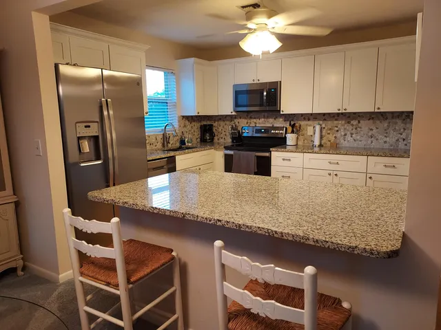 a kitchen with stainless steel appliances granite countertop a stove and a microwave