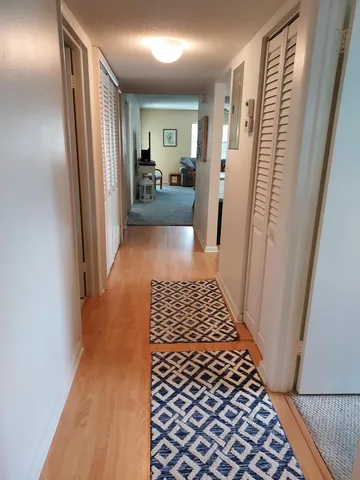 a living room with furniture a flat screen tv and kitchen view