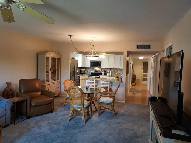 a living room with furniture and a view of kitchen