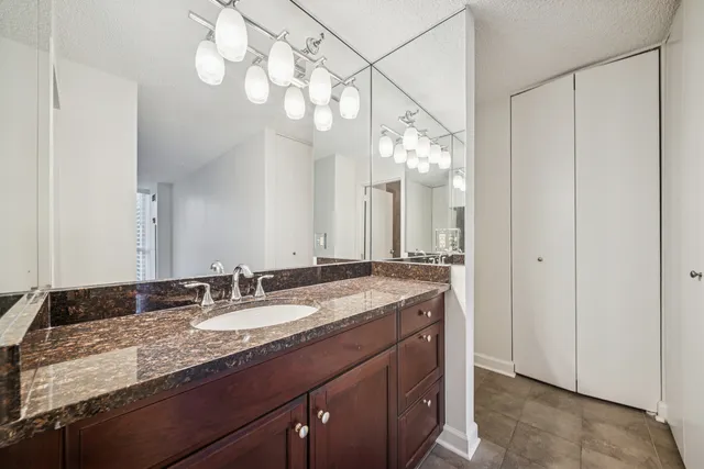 a bathroom with a granite countertop double vanity sink and mirror