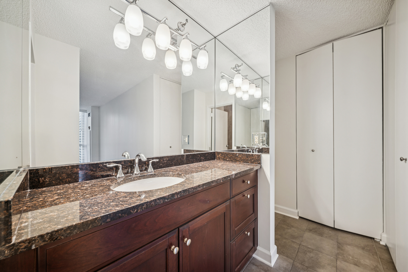 200 North Dearborn Street, Unit 3402 Chicago, IL 60601 - Photo 11 of 18 a bathroom with a granite countertop double vanity sink and mirror