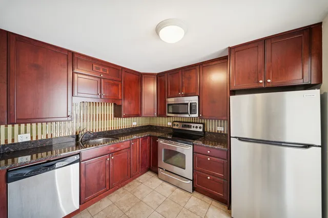a kitchen with stainless steel appliances granite countertop a refrigerator sink and cabinets
