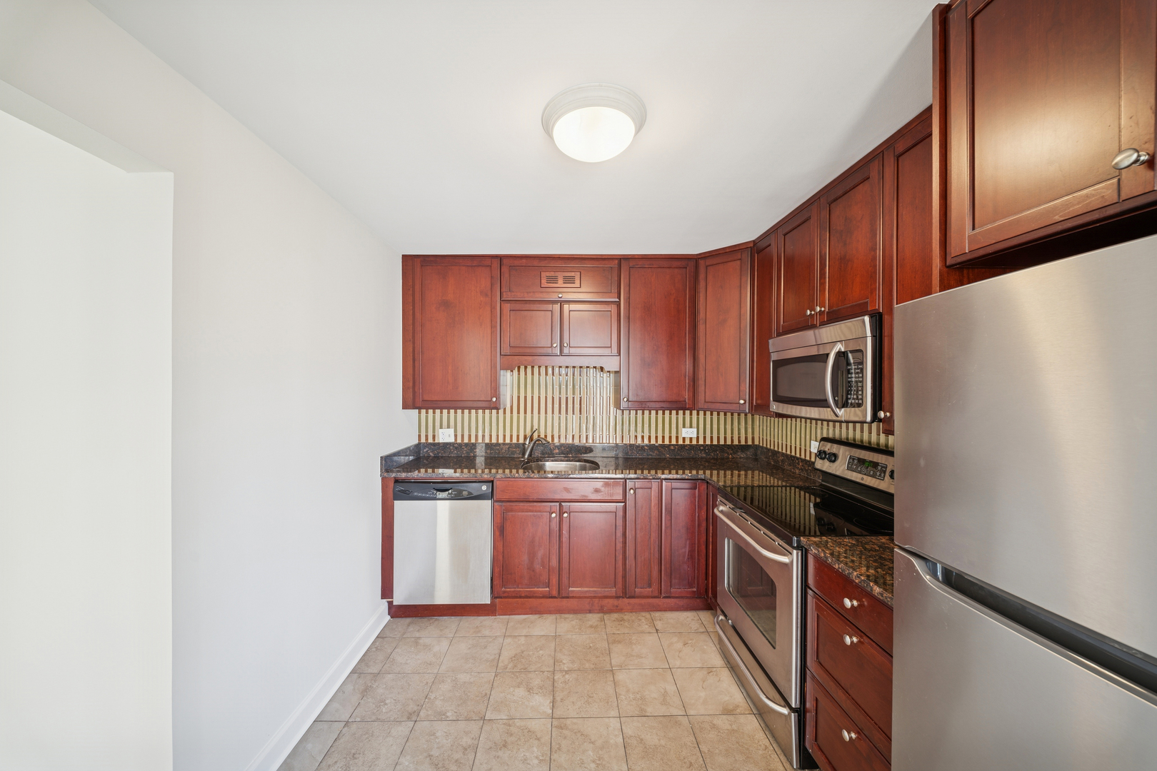 200 North Dearborn Street, Unit 3402 Chicago, IL 60601 - Photo 7 of 18 a kitchen with stainless steel appliances granite countertop a stove top oven a sink and dishwasher