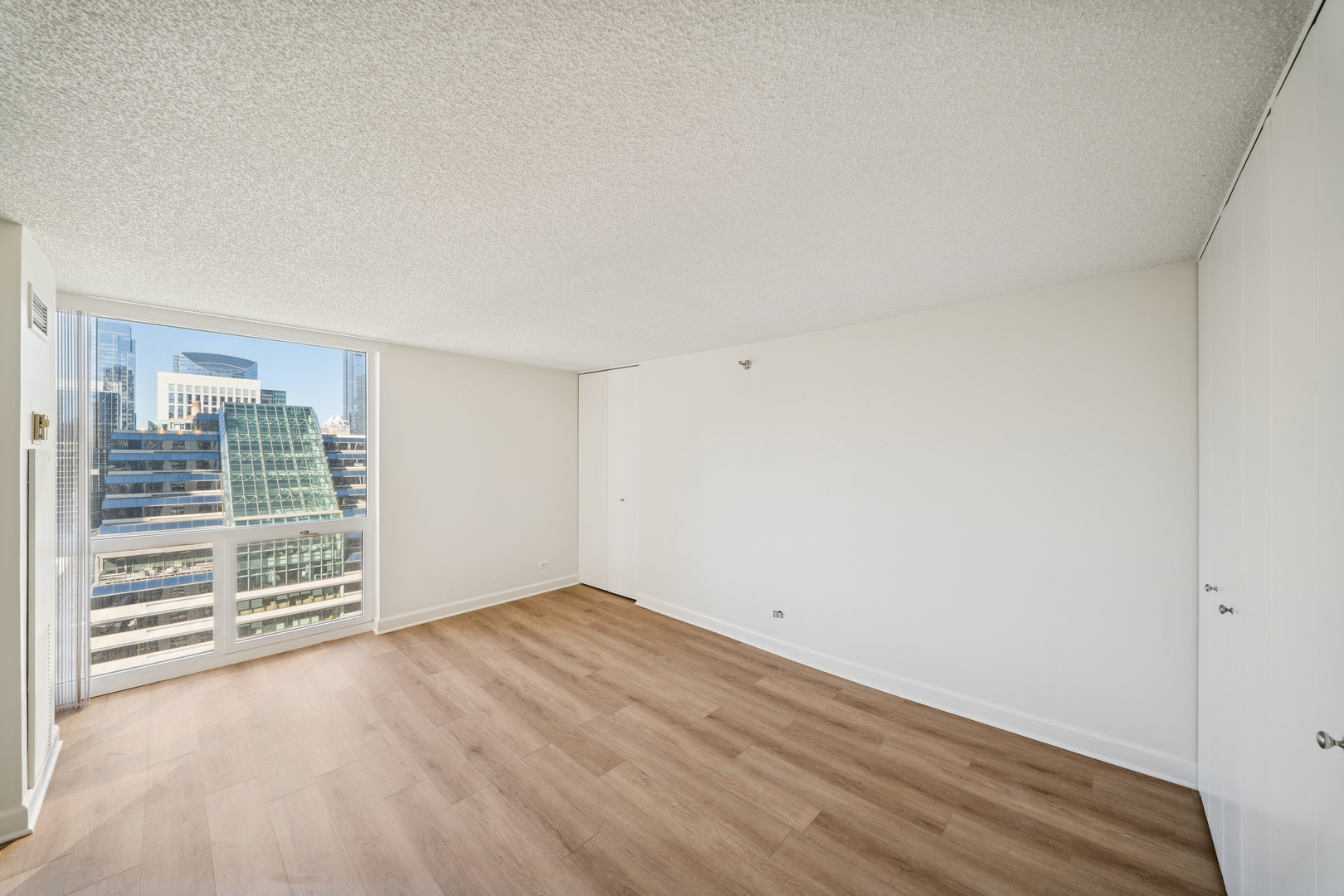200 North Dearborn Street, Unit 3402 Chicago, IL 60601 - Photo 10 of 18 a view of an empty room with wooden floor and a window