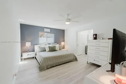 a bedroom with a bed and a flat tv screen on dresser