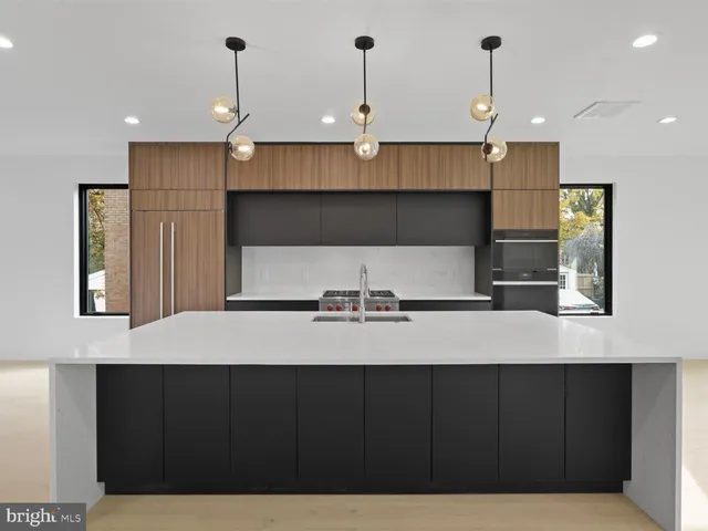 a large kitchen with a large counter top stainless steel appliances and cabinets
