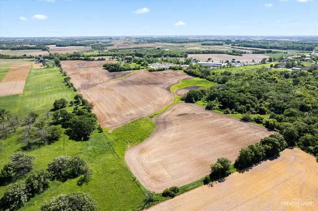an aerial view of a houses with outdoor space and trees all around