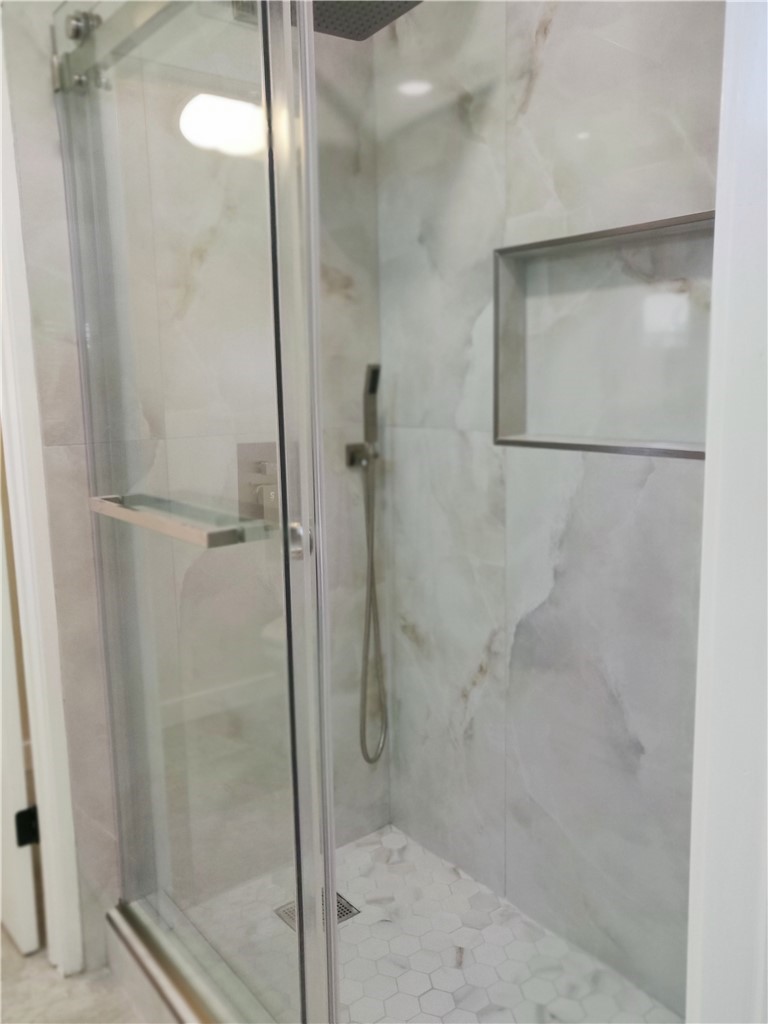 9894 Spruce Court Cypress, CA 90630 - Photo 13 of 22 a bathroom with a glass shower door