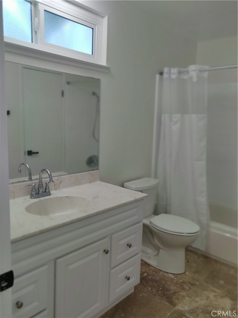 9894 Spruce Court Cypress, CA 90630 - Photo 16 of 22 a bathroom with a granite countertop toilet sink and mirror