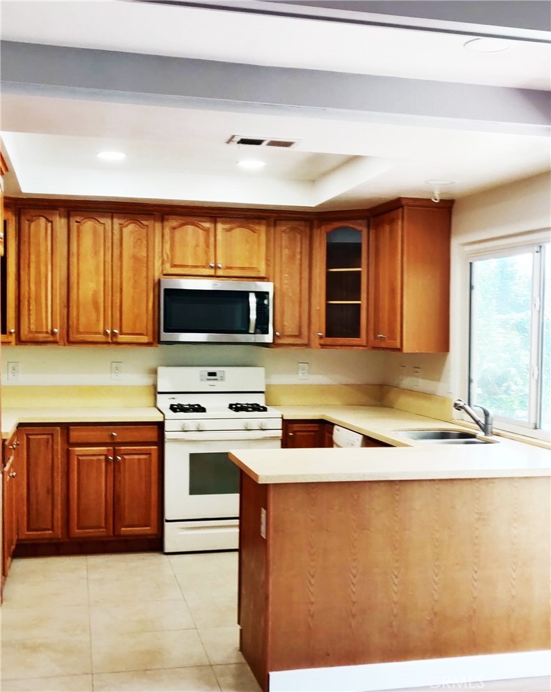 9894 Spruce Court Cypress, CA 90630 - Photo 6 of 22 a kitchen with stainless steel appliances granite countertop a stove a sink and a microwave