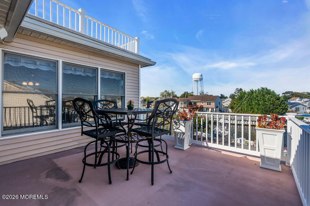 2111 Middle Avenue Point Pleasant, NJ 08742 - Photo 12 of 51 a view of a roof deck with table and chairs floor to ceiling window with wooden floor