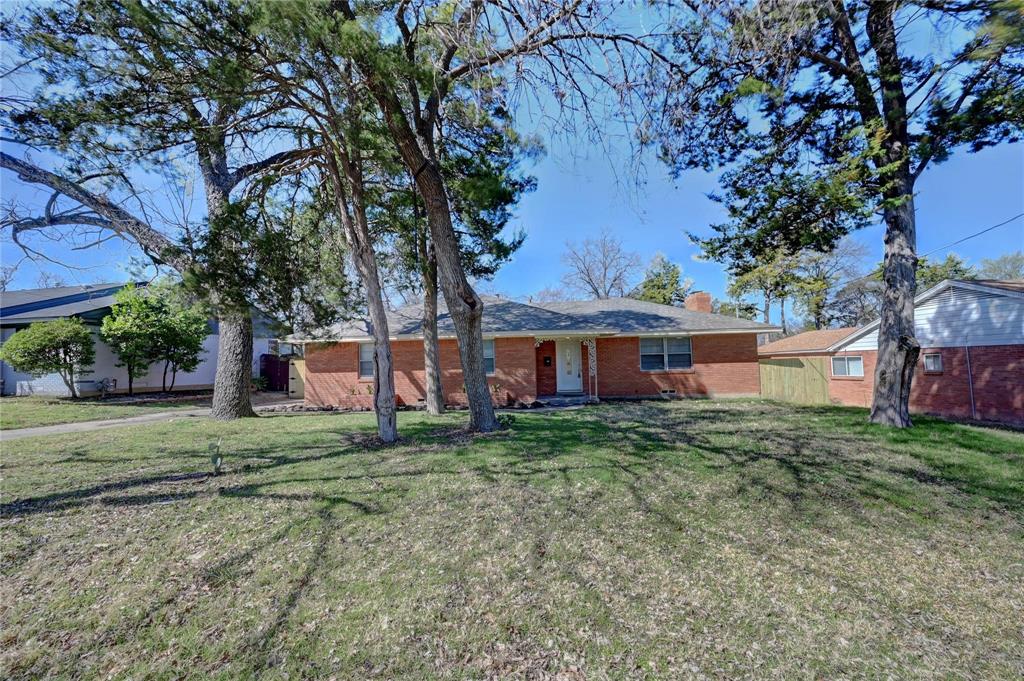 Ranch-style house featuring brick siding, a chimney, and a front lawn