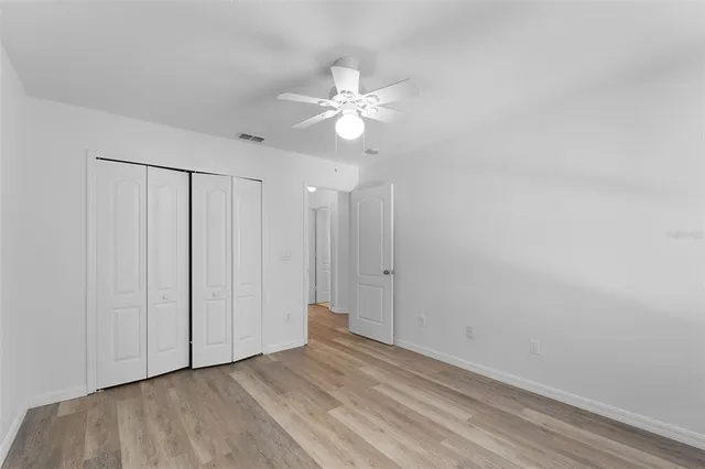 a view of an empty room and chandelier fan