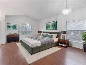 a spacious bedroom with a bed and a chandelier