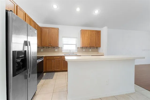 a kitchen with a refrigerator a sink and cabinets