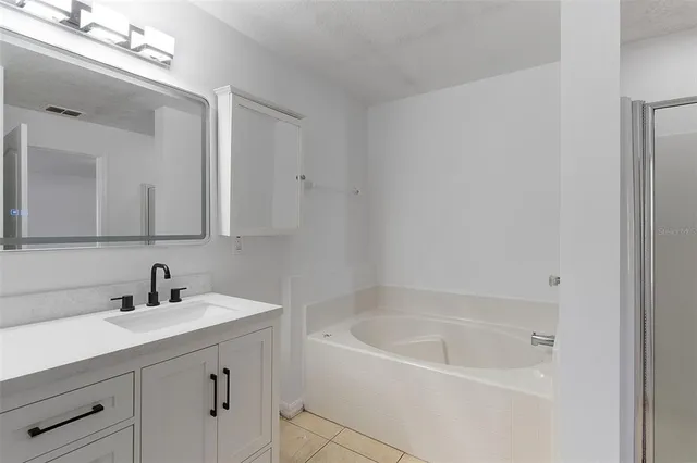 a white bath tub sitting next to a bathroom sink