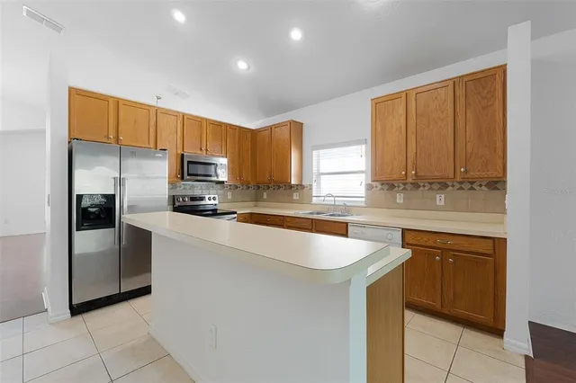 a kitchen with granite countertop a sink stainless steel appliances and counter space