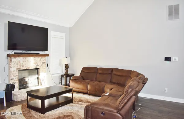 a living room with furniture a flat screen tv and a fireplace