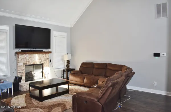 a living room with furniture a flat screen tv and a fireplace