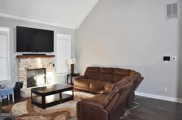 a living room with furniture a flat screen tv and a fireplace