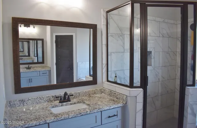 a bathroom with a granite countertop sink and a mirror