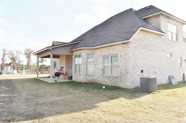 a view of a house with backyard and sitting area
