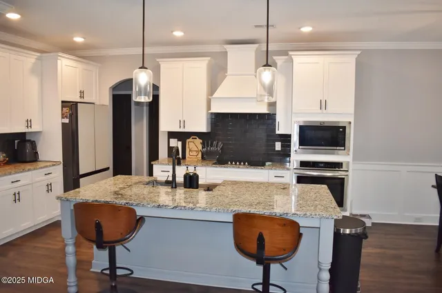 a kitchen with stainless steel appliances granite countertop a sink refrigerator and microwave