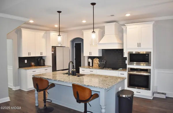 a kitchen with kitchen island granite countertop a stove and a refrigerator