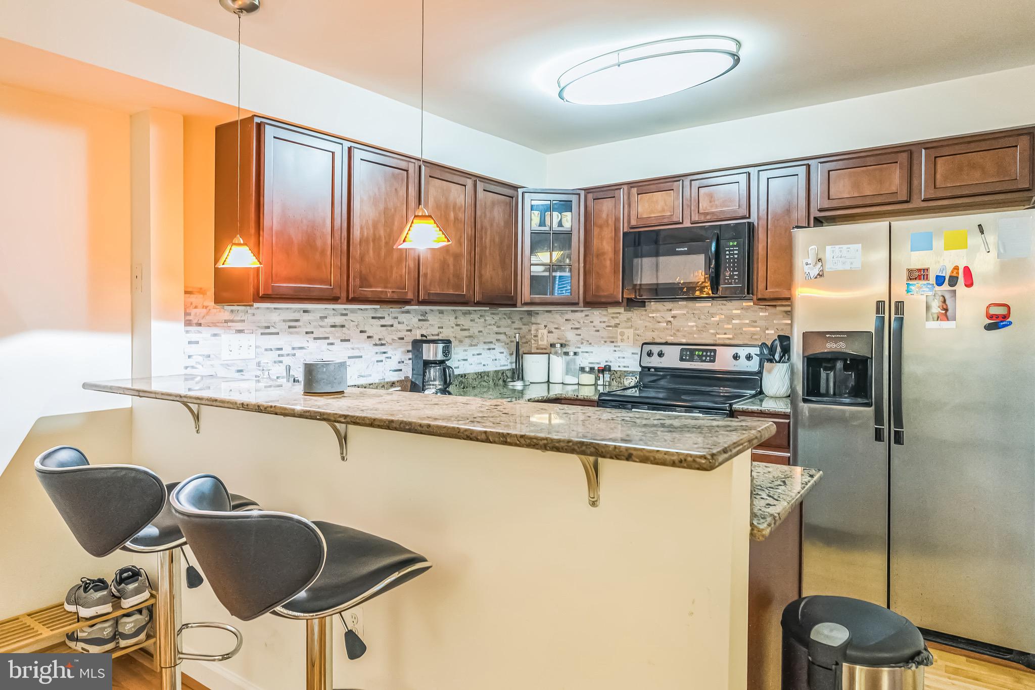 5040 1st Street Northwest, Unit 301 Washington, DC 20011 - Photo 3 of 22 a kitchen with stainless steel appliances granite countertop a sink and a refrigerator