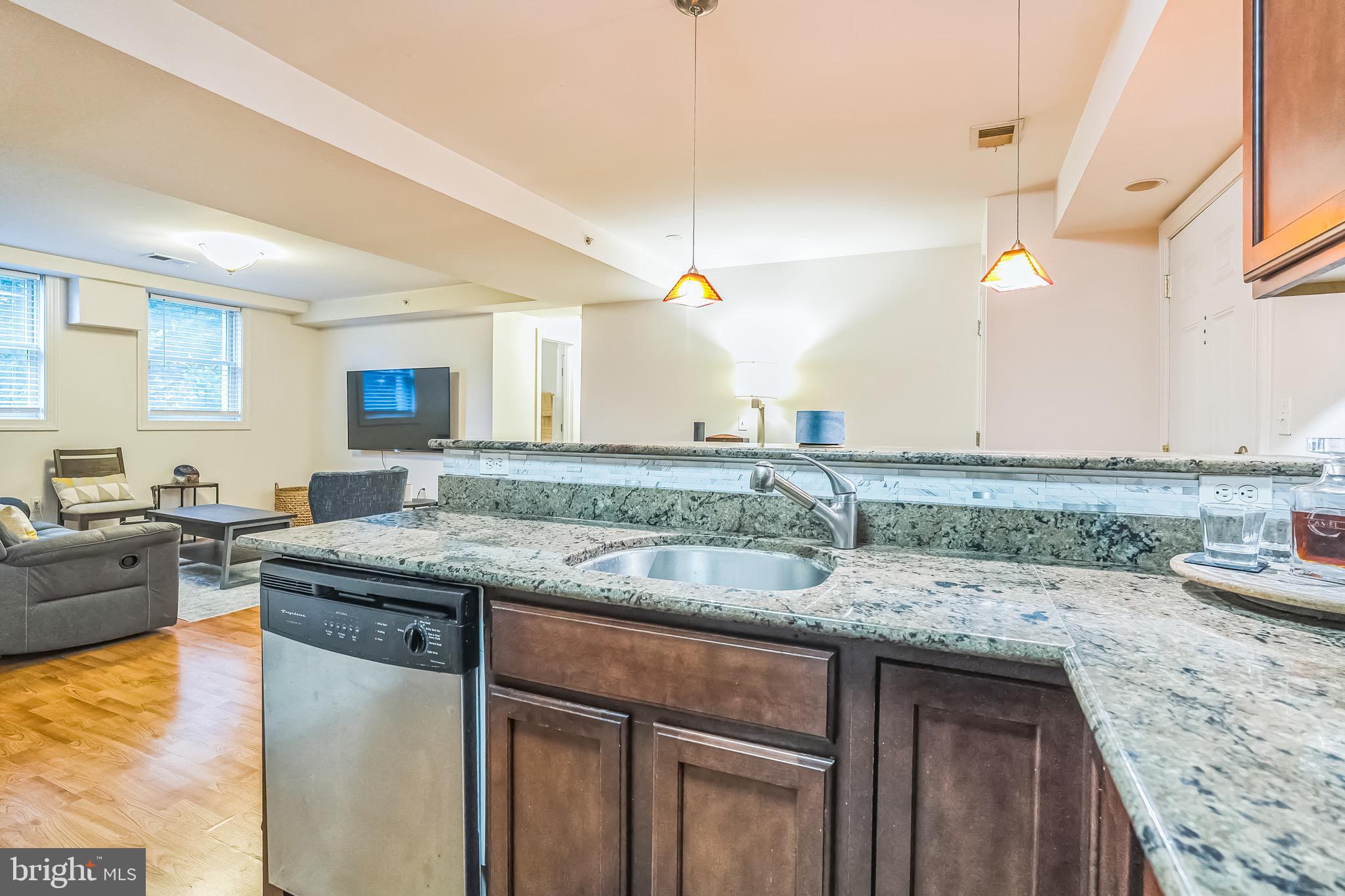 5040 1st Street Northwest, Unit 301 Washington, DC 20011 - Photo 4 of 22 a kitchen with stainless steel appliances granite countertop a sink a stove and a wooden cabinets