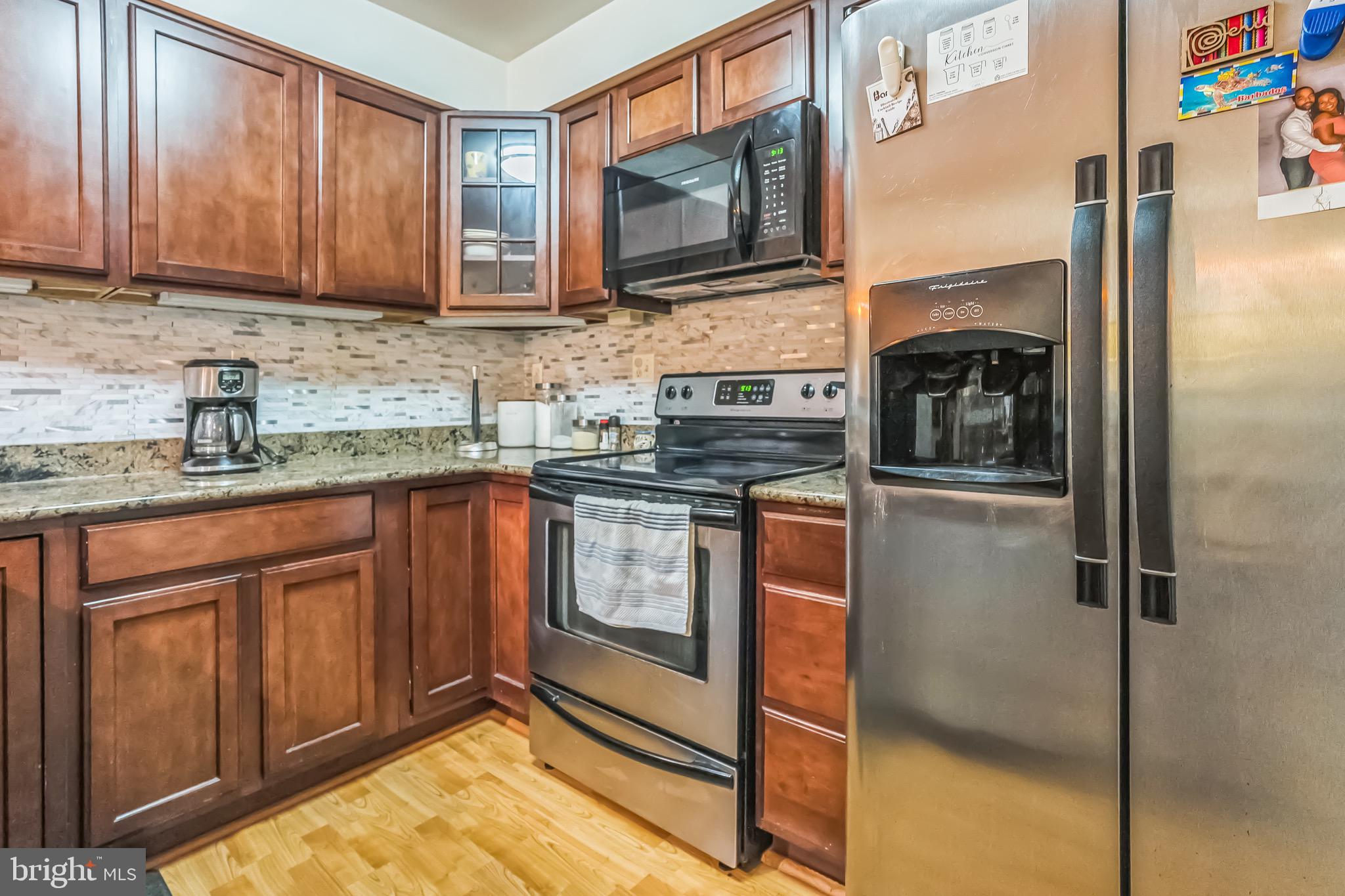5040 1st Street Northwest, Unit 301 Washington, DC 20011 - Photo 5 of 22 a kitchen with stainless steel appliances granite countertop a stove microwave and refrigerator