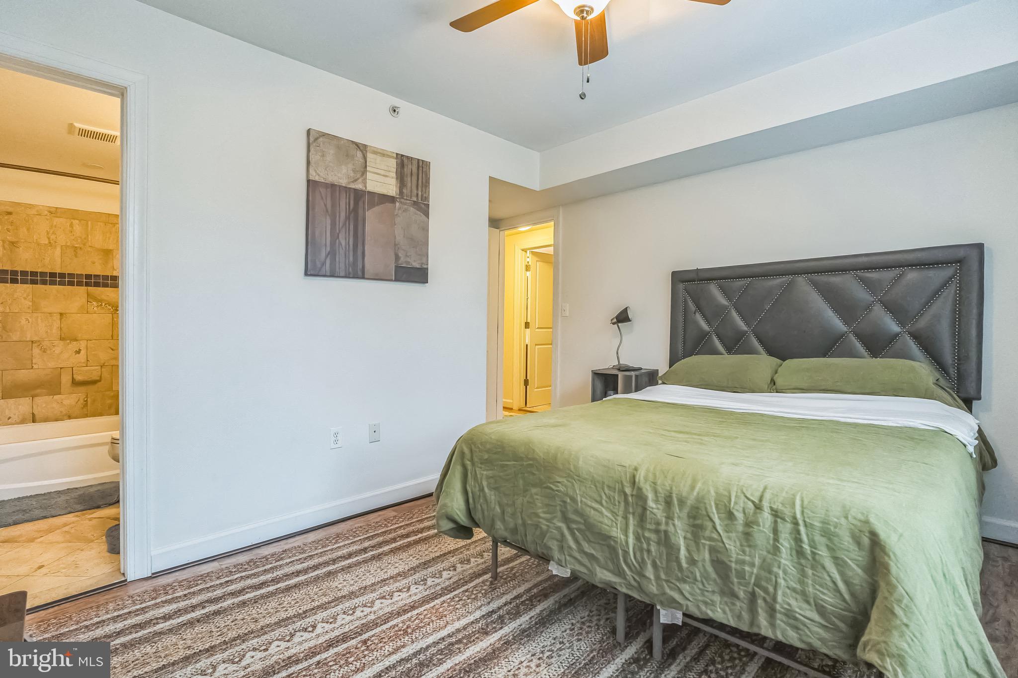 5040 1st Street Northwest, Unit 301 Washington, DC 20011 - Photo 7 of 22 a bedroom with a bed and wooden floor