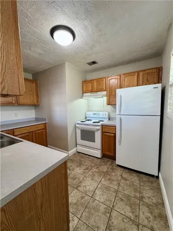 a white refrigerator freezer and a stove in a kitchen