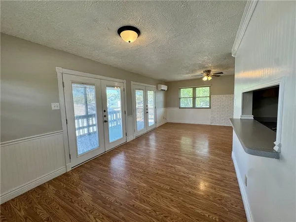 a view of empty room with wooden floor and windows
