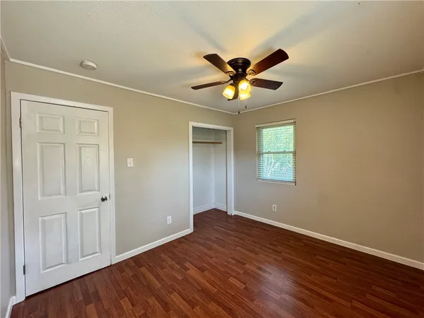 a view of a room with wooden floor closet and windows