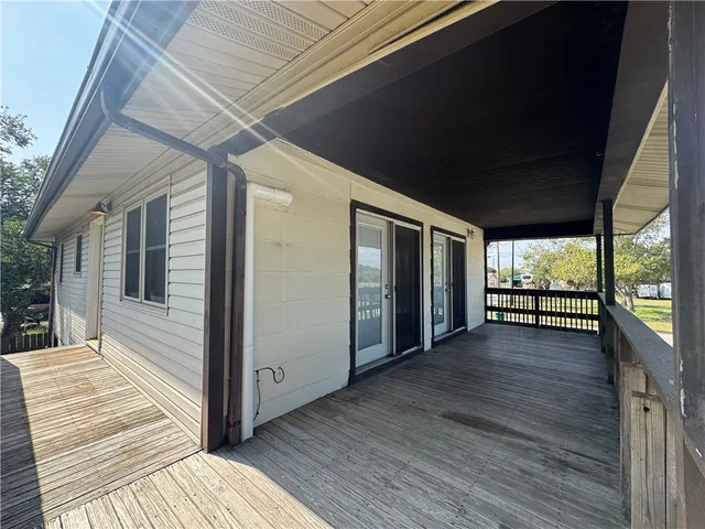 a view of a porch with wooden floor and brick walls