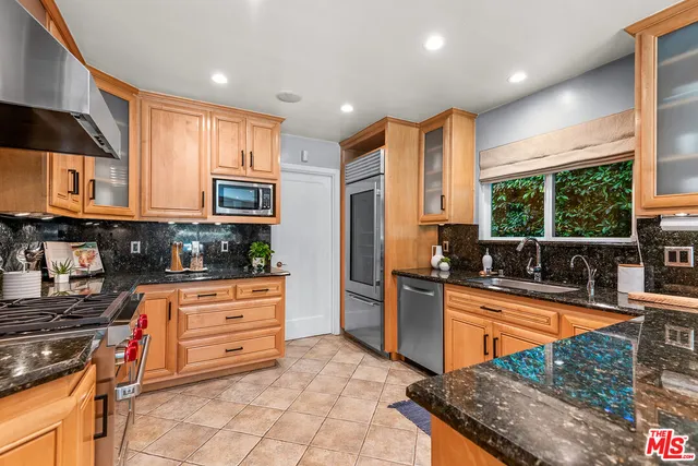 a kitchen with stainless steel appliances granite countertop a stove a sink and a refrigerator