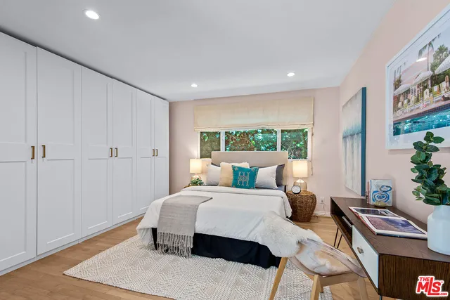 a bedroom with a bed and a table with potted plants