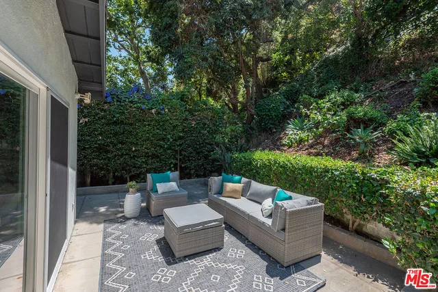 a view of backyard with couches under an umbrella