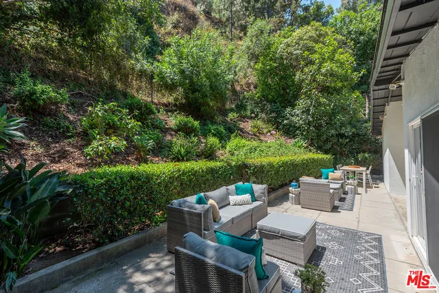 a view of a patio with couches table and chairs and potted plants