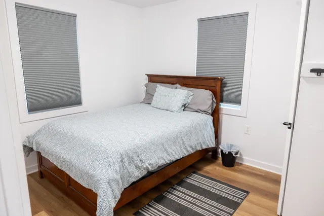 a bedroom with a bed and wooden floor