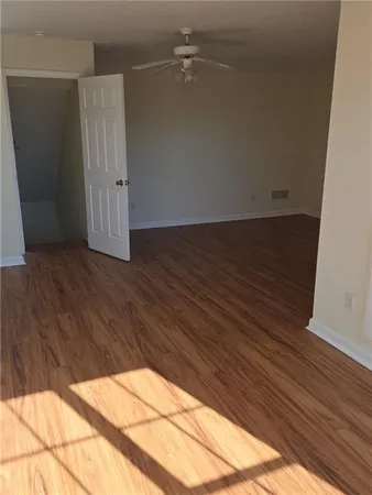an empty room with wooden floor and cabinet