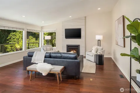 a living room with furniture a flat screen tv and a fireplace