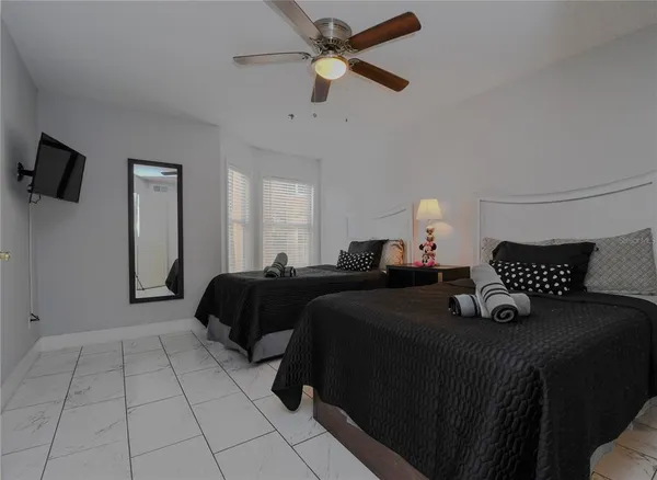 a bedroom with a bed and a ceiling fan